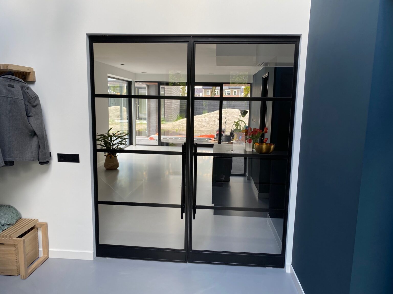 Zwarte stalen deuren die een keuken afsluiten