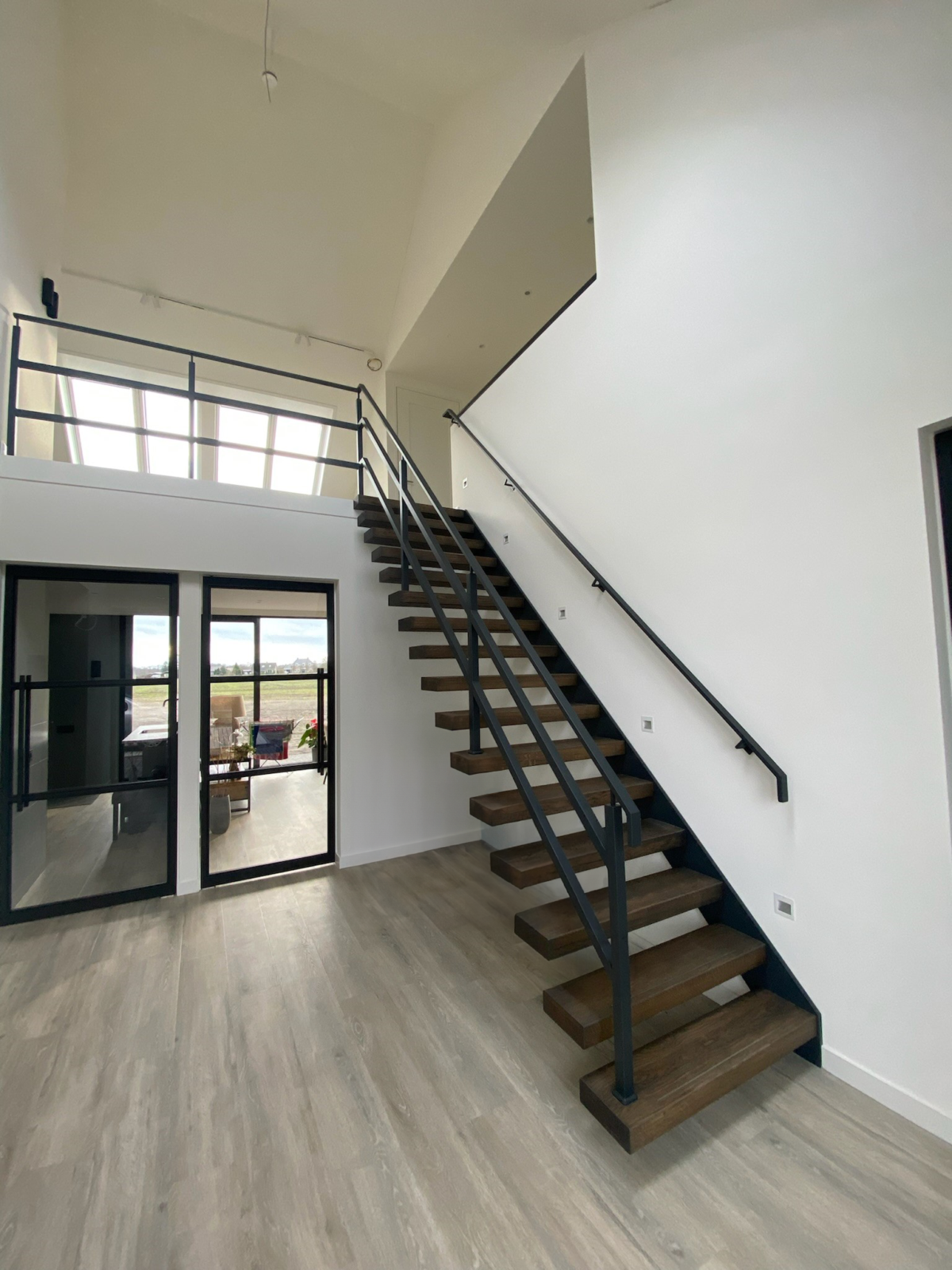 Zwevende trap van staal met houten treden