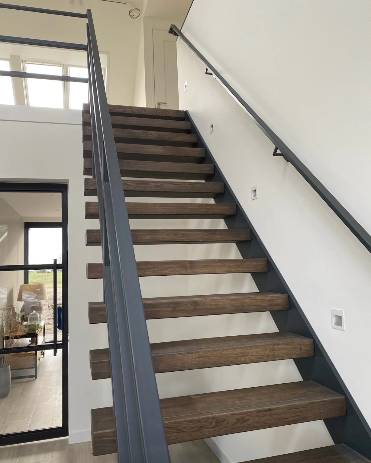 Zwevende trap van staal met houten treden