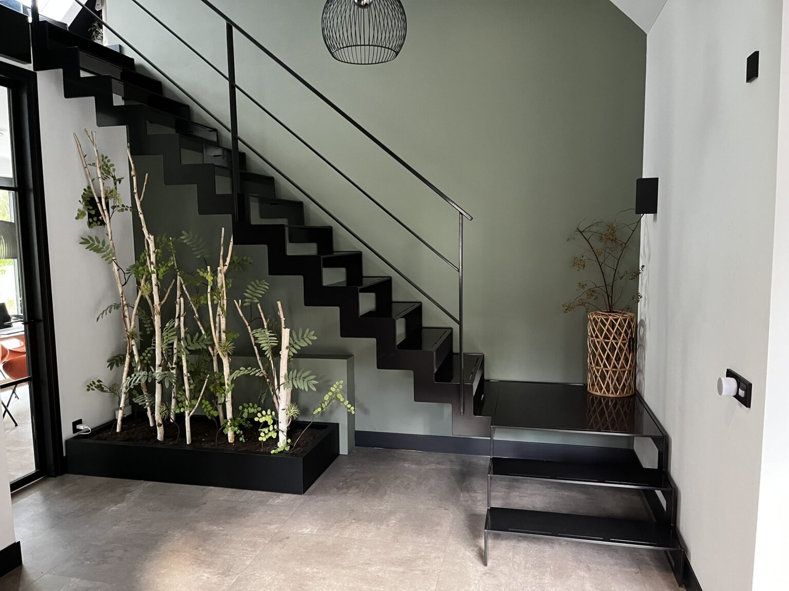 Zwarte ijzeren trap in entree van woning met bordes