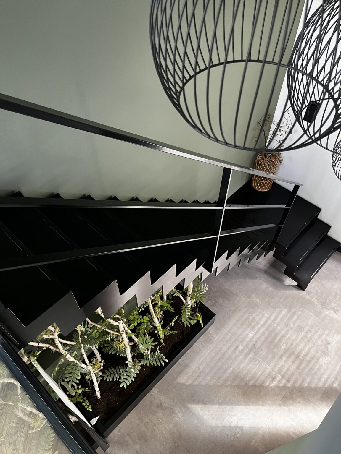 Bovenaanzicht van een zwarte ijzeren trap in entree van woning