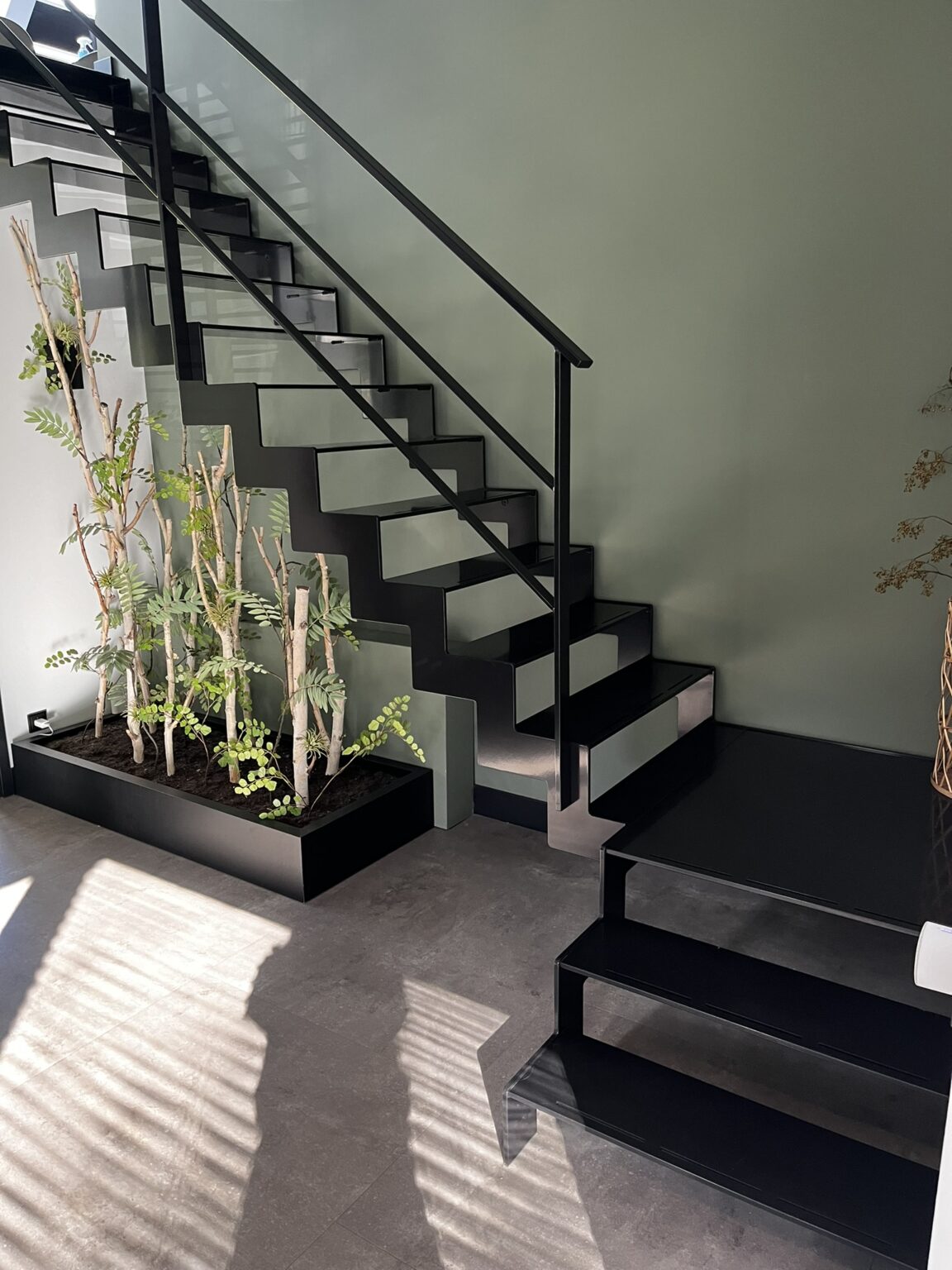 Zwarte ijzeren trap in entree van woning met bordes